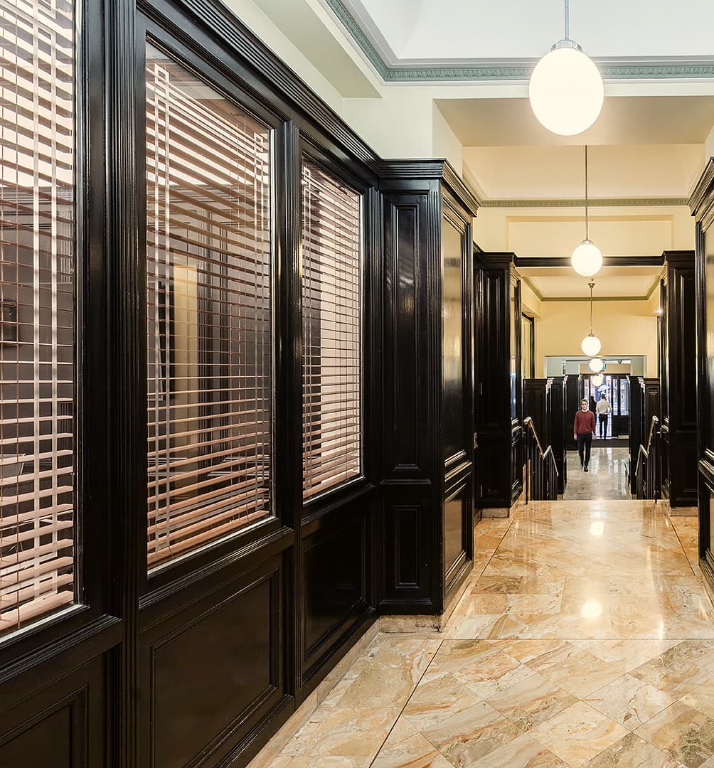 Marble-floored arcade lined with black timber panelling