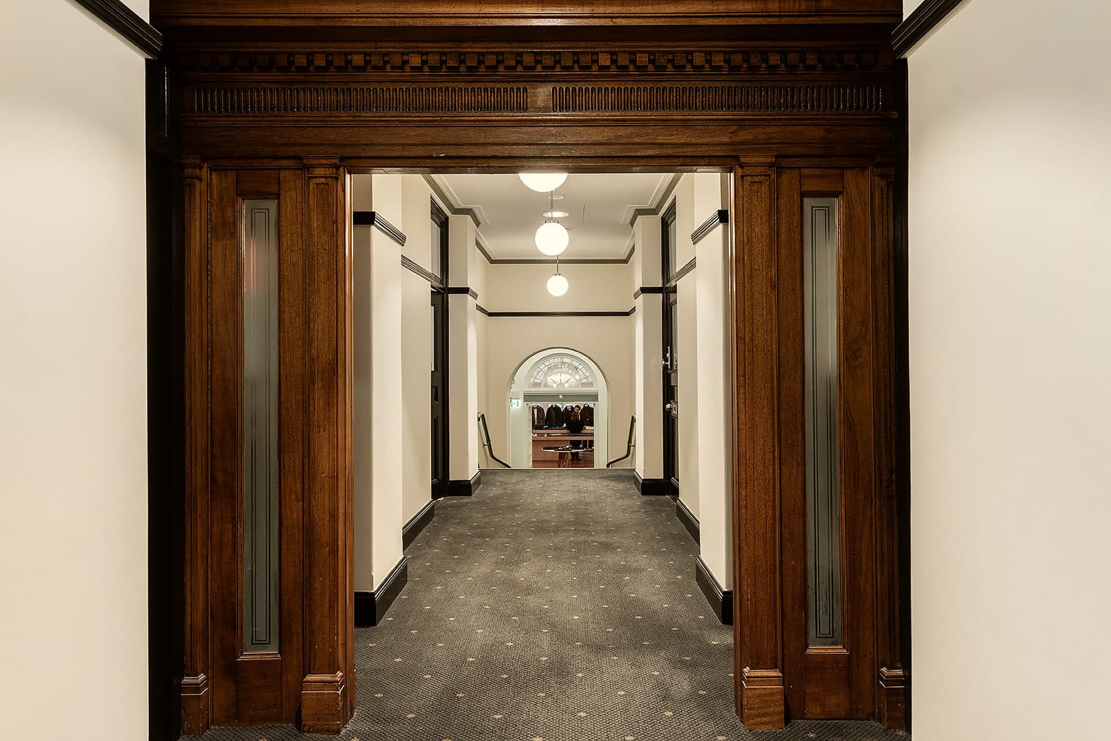 Carved timber archway opening onto a quiet corridor